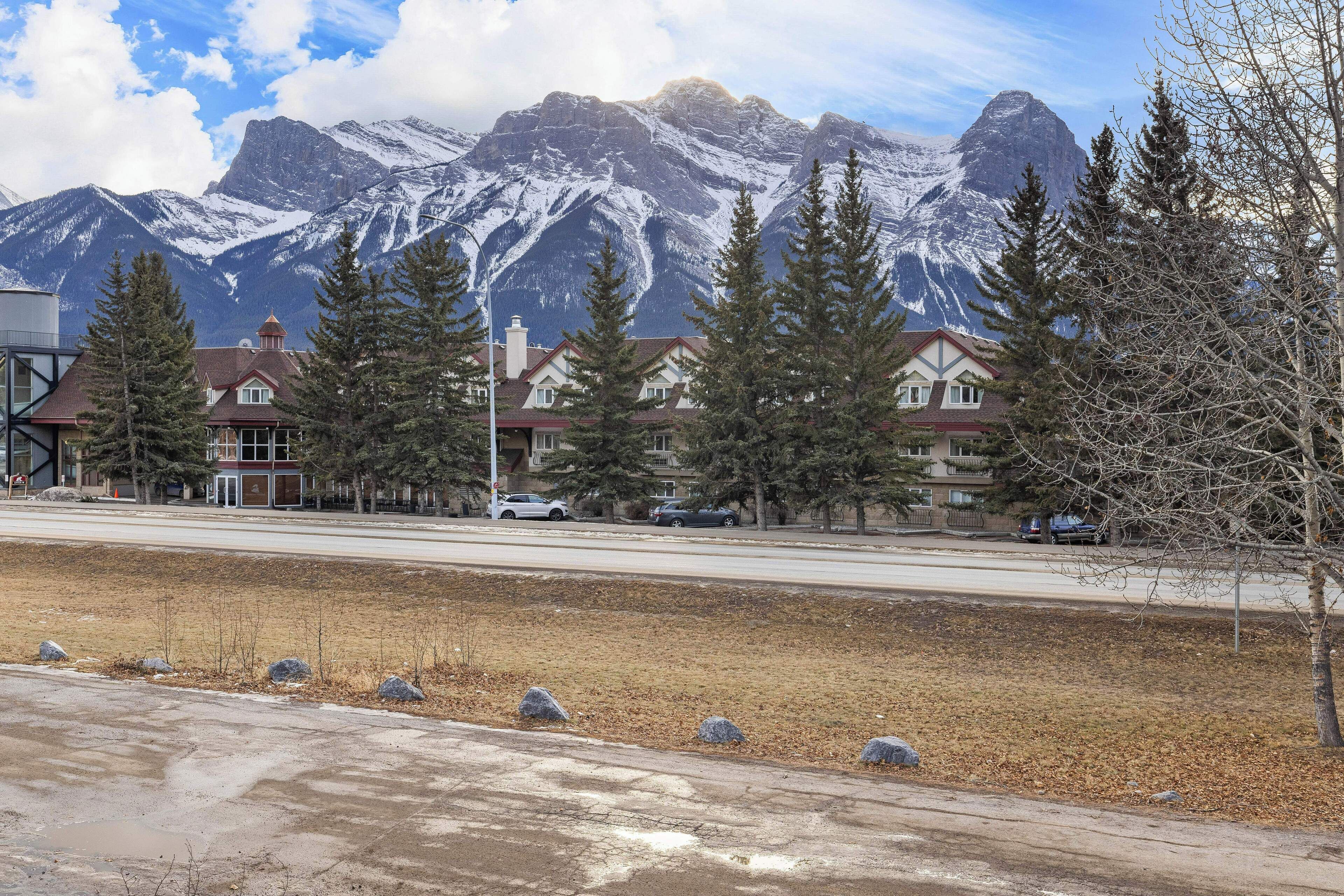 Zona residencial con casas, una carretera y una cordillera al fondo.