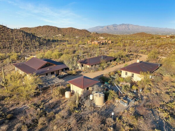 Paisaje desértico con varios edificios de techos rojos, rodeado de vegetación escasa y cactus.