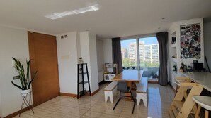 Un apartamento moderno con comedor, cocina y balcón con vista a la ciudad.