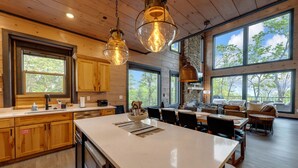 A spacious kitchen with large windows, wooden cabinets, and a central island. - New/Theater/Indoor pool/Hot tub/Fire pit/Arcades/View (Sevierville)