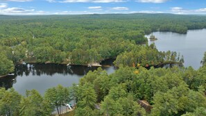 A lake surrounded by dense forest with a small island and a dock.