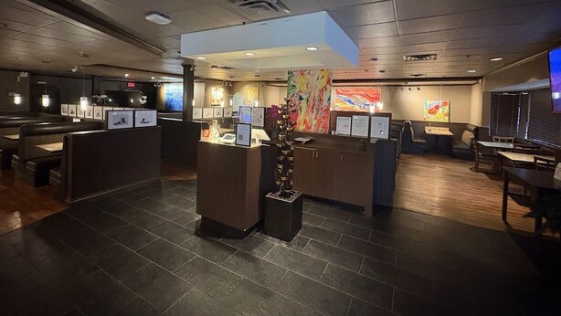 A modern hotel lobby with a reception desk, seating areas, and artwork on the walls.