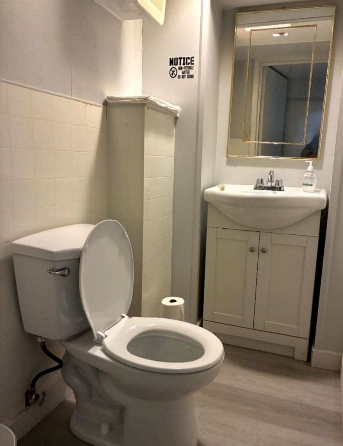 Un baño con inodoro, lavamanos y espejo.
