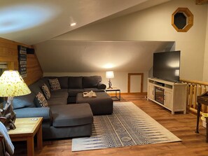 TV connectée, cheminée, livres, chaîne hi-fi