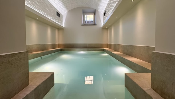 Ein großer, überdachter Innenpool mit hoher Decke und Oberlichter.
