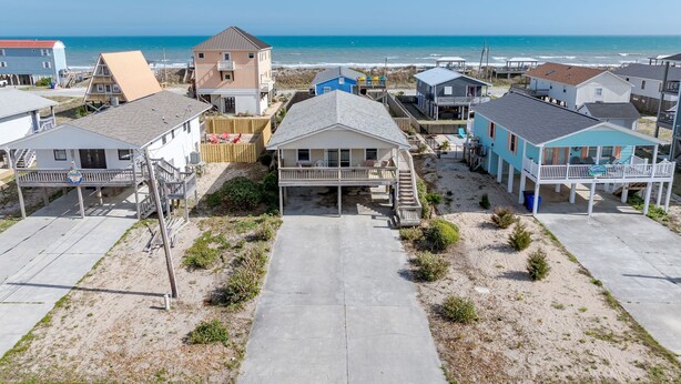 A beachfront residential area with houses featuring balconies and a view of the ocean.