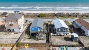 A coastal residential area with beachfront properties, including houses with attached decks and a beach path.