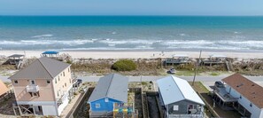 A coastal residential area with beachfront properties, including houses with attached decks and a beach path.