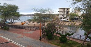 A waterfront view with a paved walkway, benches, and a building in the background. - Master Suite Plus Ocean View Balcony (San Cristóbal)