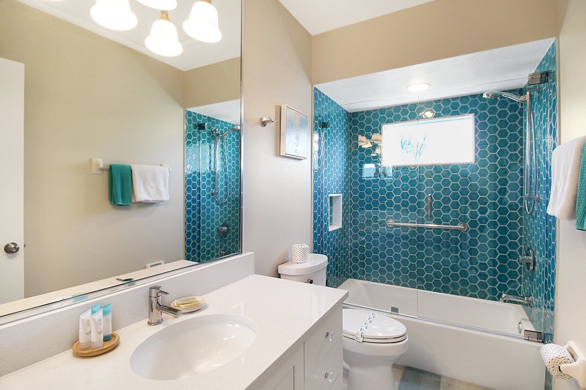 Een badkamer met een wit wastafel, toilet en douche met glazen deur.