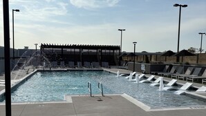 A rooftop pool with a water feature, lounge chairs, and a pergola. - Cozy Luxury Unit Convenient location (Decatur)