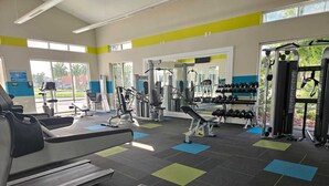A gym with treadmills, weight machines, and dumbbells. - Steps away from Resort Pool, Kids Water Park, Hot tub and Gym (Kissimmee)