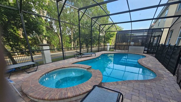 A swimming pool with a hot tub and a covered area with a bench. - Steps away from Resort Pool, Kids Water Park, Hot tub and Gym (Kissimmee)
