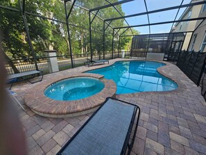 A swimming pool with a hot tub and a covered area with a bench. - Steps away from Resort Pool, Kids Water Park, Hot tub and Gym (Kissimmee)