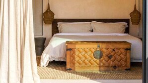 Un dormitorio con cama, ventilador de techo y dos lámparas colgantes.