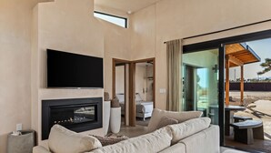 Una sala moderna con chimenea, televisor de pantalla plana y un sofá grande.
