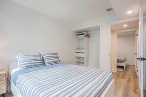 Ein Schlafzimmer mit Bett, Kleiderschrank und begehbarem Kleiderschrank.
