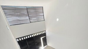 En trappa med ett metallräcke som leder upp till en liten plattform med en vägg som har ett svartvitt mönster.