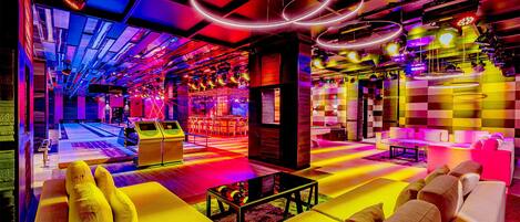 Un salón vibrante con mobiliario moderno, mesa de billar y bar.