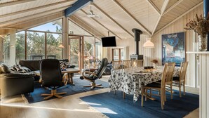 A spacious living area with a large table, comfortable seating, and a fireplace. - Lovely home in Ringkøbing with sauna (Ringkøbing)