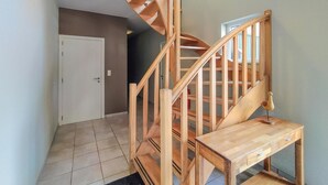 A wooden staircase with a handrail, a small wooden table, and a door in a hallway. - Stunning home in Durbuy with sauna (Durbuy)