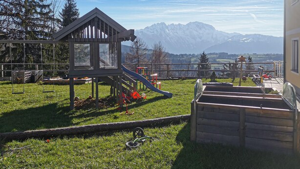 A playground with a slide and swings, set against a backdrop of snow-capped mountains. - Ferienwohnung in Sankt Koloman (Sankt Koloman)