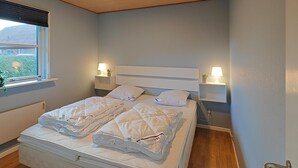 A neatly made bed with two pillows and two bedside tables with lamps. - 3 bedroom awesome home in Hjørring (Hjørring)
