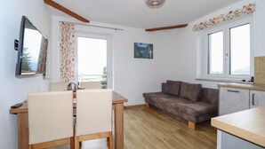 Un espacio habitable compacto con comedor, sofá y kitchenette.