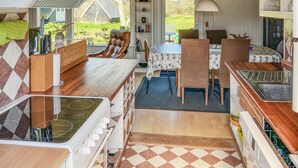 A compact kitchen with a stove, sink, and dining area. - 4 bedroom amazing home in Hurup Thy (Hurup Thy)