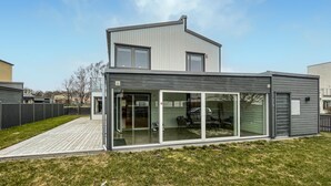 A modern two-story house with a large glass door entrance and a covered patio area. - Gorgeous home in Varberg with WiFi (Varberg)