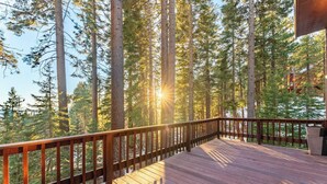 A wooden deck with a railing overlooking a forested area. - Views + Mins to Skiing, Lake, & Incline Village Incline Serenity by Avantstay (Incline Village)