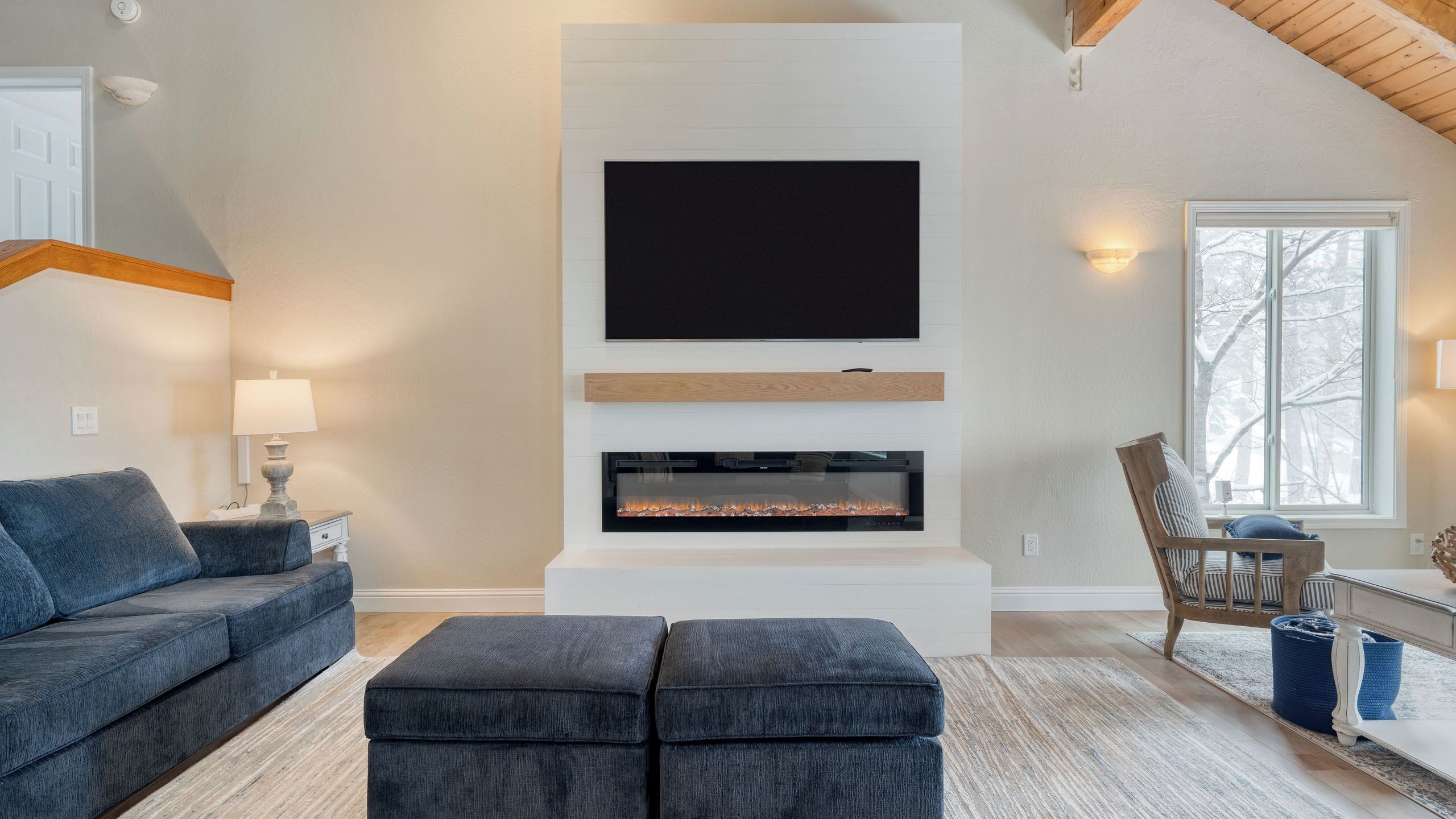Una sala moderna con televisor de pantalla plana, chimenea y un espacio de estar acogedor.