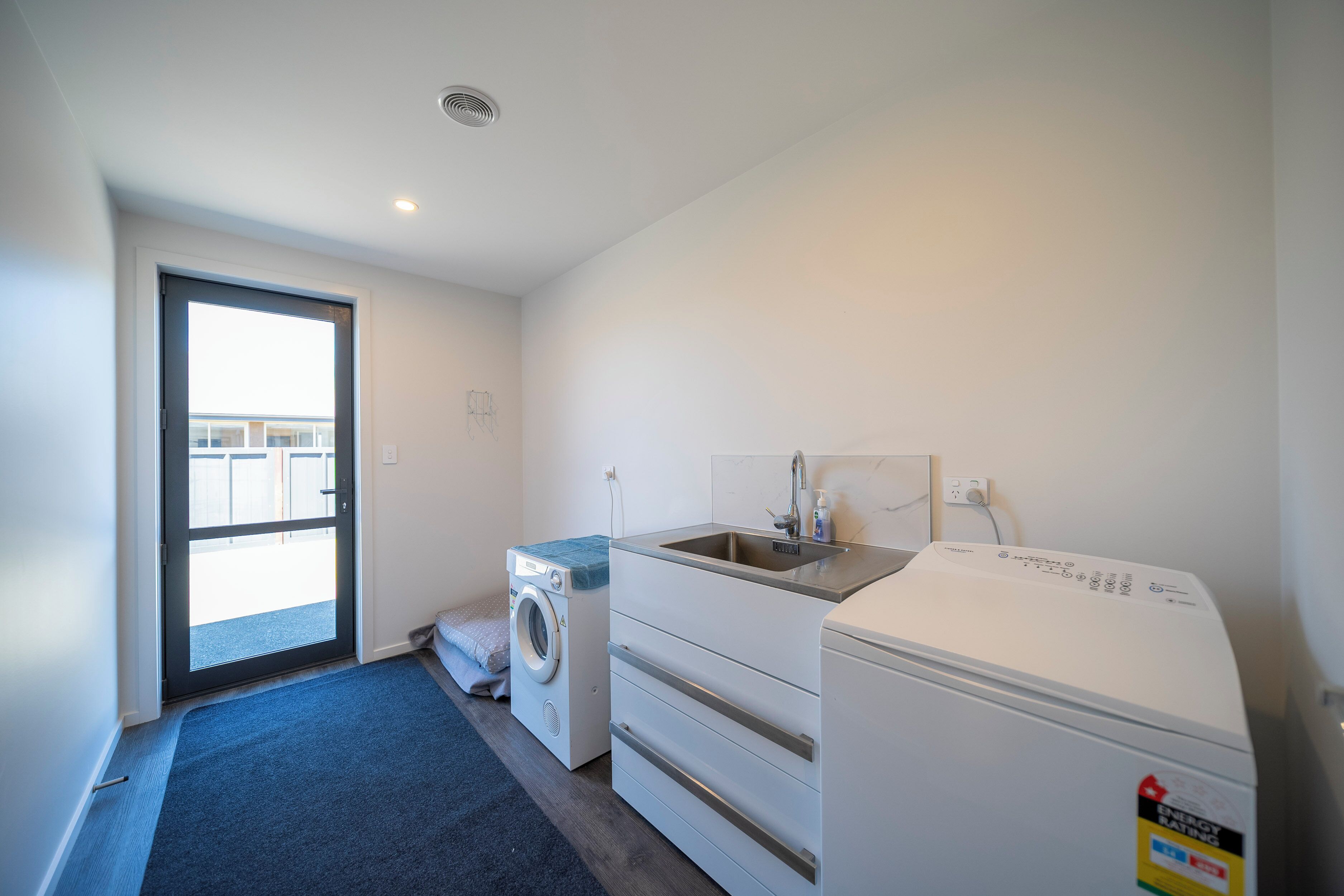 A laundry room with a washing machine, dryer, and sink.