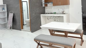 A modern kitchen with a white countertop, wooden cabinets, and a built-in stove. - Periférico Bodega con Departamento C (Tonalá)