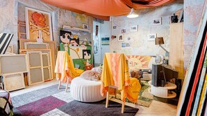 Ein gemütliches Zimmer mit einem großen Bett, einem Schreibtisch und einer Wand voller Karten.