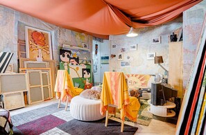 Una habitación acogedora con una cama grande, un escritorio y una pared cubierta de mapas.