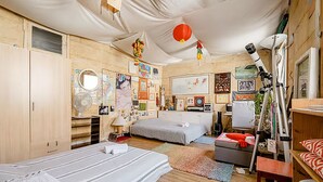 Ein Schlafzimmer mit zwei Betten, einem Schreibtisch und einem Teleskop.
