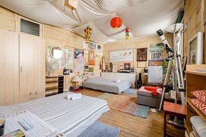 Un dormitorio con dos camas, un escritorio y un telescopio.