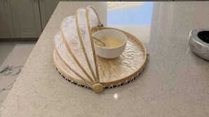 A kitchen with a large window, a marble countertop, and a decorative woven mat with a bowl of yellow liquid on it. - White Sky Beach Villas (New Hope)