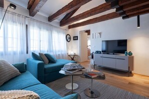 En moderne stue med en sofa, et sofabord og et fjernsyn.