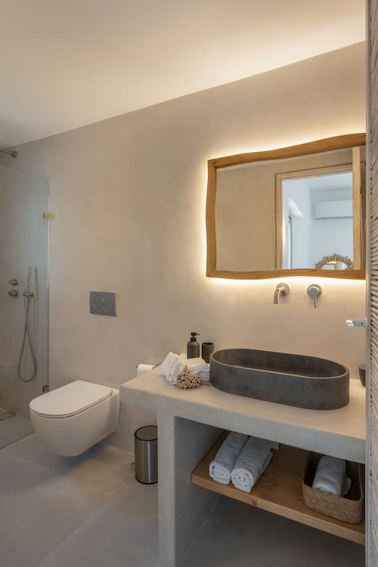 Une salle de bain moderne équipée de toilettes, d’un grand lavabo et d’une douche.