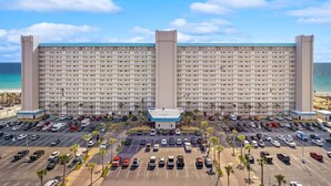 A large hotel with multiple floors, a parking lot, and a beach view. - Oceanfront, 2nd Floor, Sea View, 2 Pools (Panama City Beach)