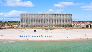 A large hotel with multiple floors and balconies, situated on a beach with clear turquoise waters. - Oceanfront, 2nd Floor, Sea View, 2 Pools (Panama City Beach)
