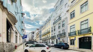 A street lined with multi-story buildings, some with balconies, and a row of parked cars. - Vibrant Central Studio (Lisbon)
