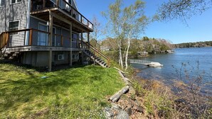 Ett hus med flera våningar, en balkong, en brygga och utsikt över floden.