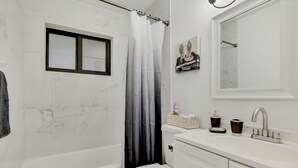 A bathroom with a bathtub, toilet, and sink.