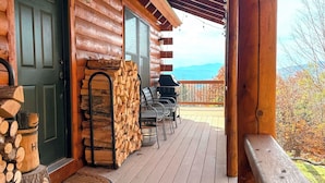 A wooden cabin with a porch, a grill, and a stack of firewood. - 9N Mountainside Cabin in Franconia Heights, Dog Friendly, Stunning Views! (Franconia)