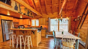 A wooden cabin with a kitchen, dining area, and bar stools. - 9N Mountainside Cabin in Franconia Heights, Dog Friendly, Stunning Views! (Franconia)