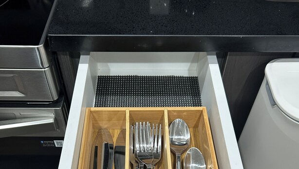 A drawer with neatly organized silverware including forks, knives, and spoons. - Charming 1-Bedroom Basement Walkout Suite with a Gym and Office. (Calgary)