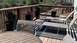 A deck with a round table and chairs, surrounded by potted plants and a view of mountains. - 4BR Mountain Retreat , Fireplace, Deck with Views, RMNP (Fraser)
